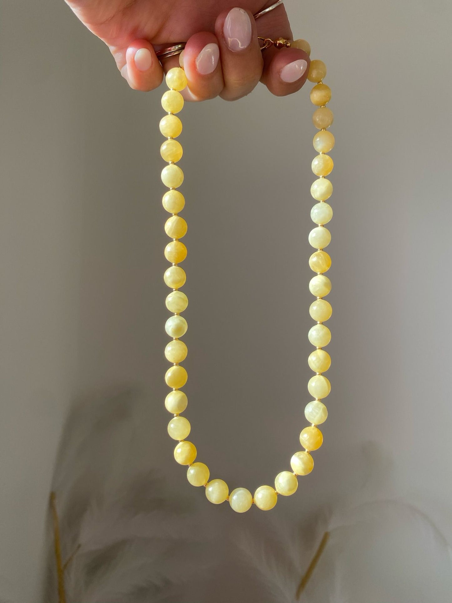 Beaded necklace with large smooth lemon yellow gemstone beads and gold seed spacers