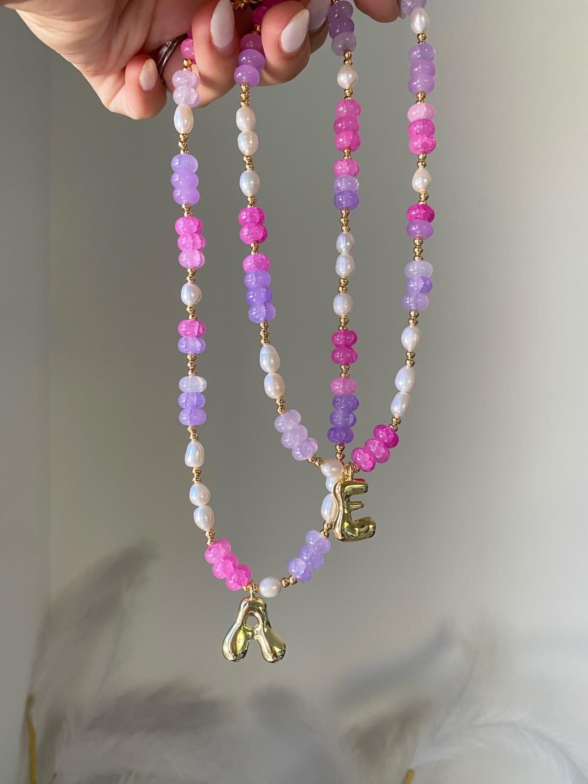 Beaded necklace featuring hot pink and lilac gemstone rondelle beads with freshwater pearl accents, gold spacers and a gold balloon letter initial charm pendant