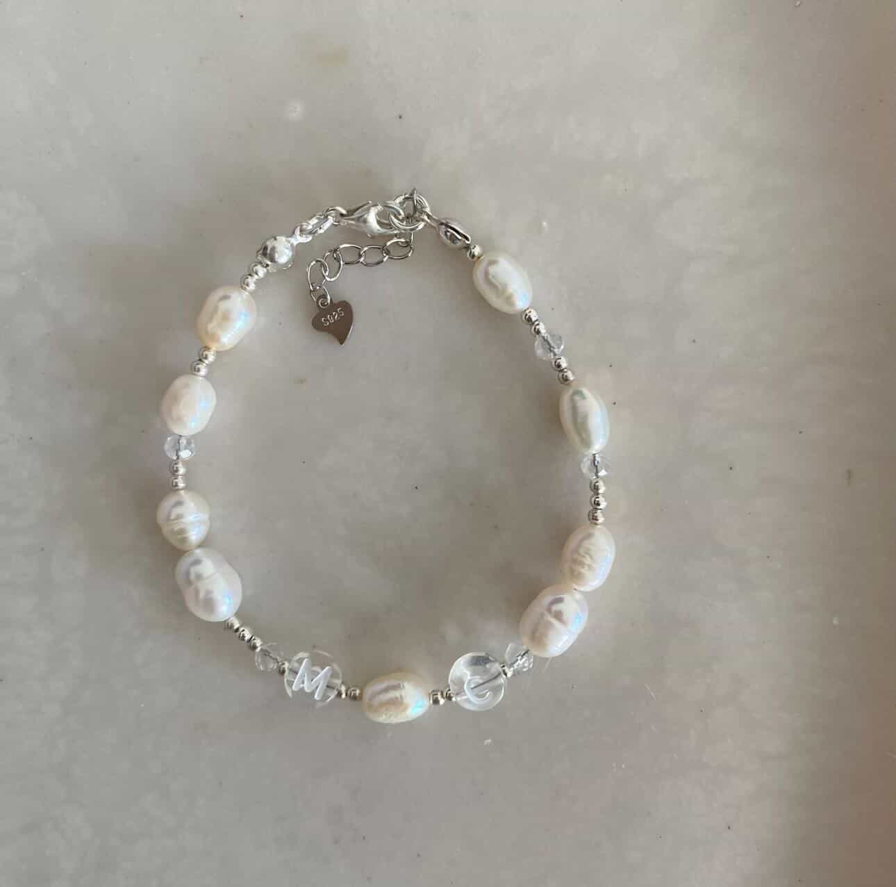 Sterling silver bracelet with freshwater pearls, and clear acrylic beads with the initials M and C.