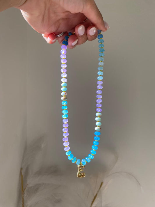 Bbeaded necklace featuring lilac, sky blue, aqua and turquoise gemstone rondelle beads with gold spacers and a gold balloon letter E initial charm pendant